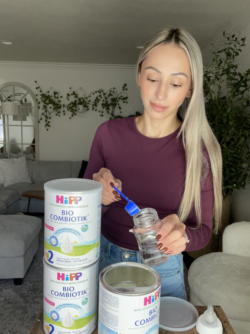 Kseniia measuring a scoop of HiPP Dutch into a bottle